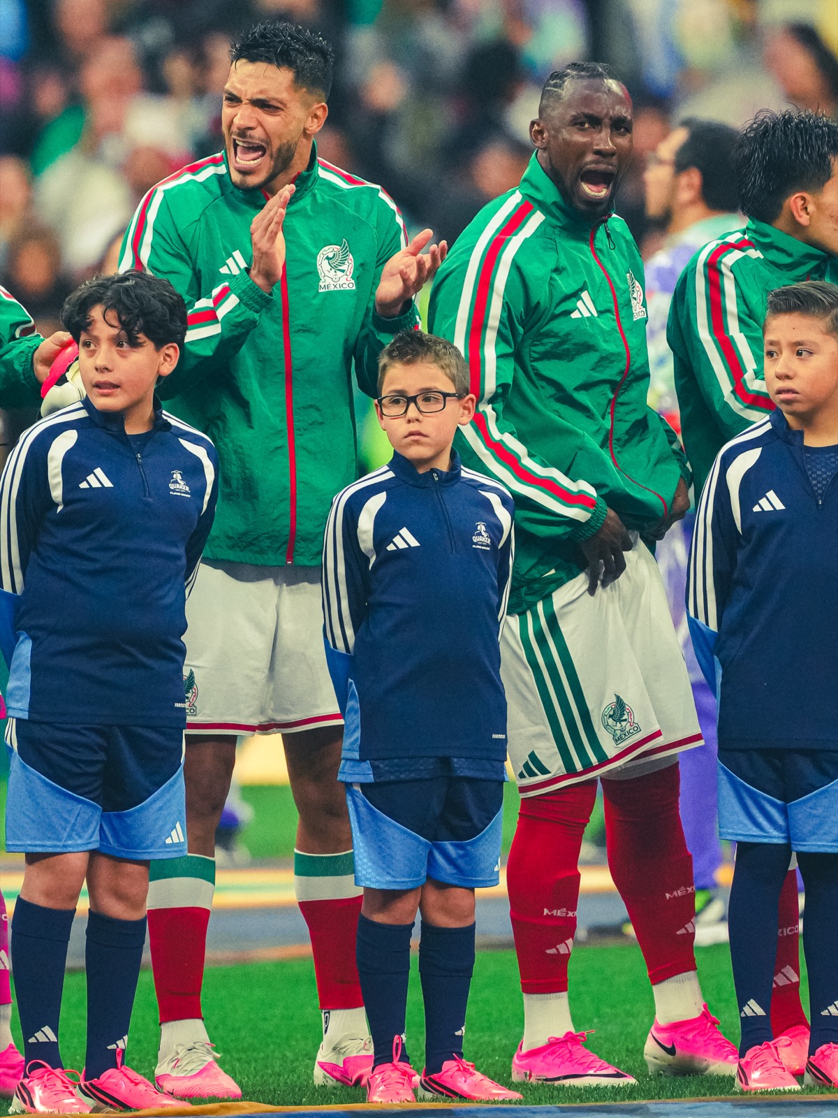 Jugadores cantan el himno junto a niños antes del partido